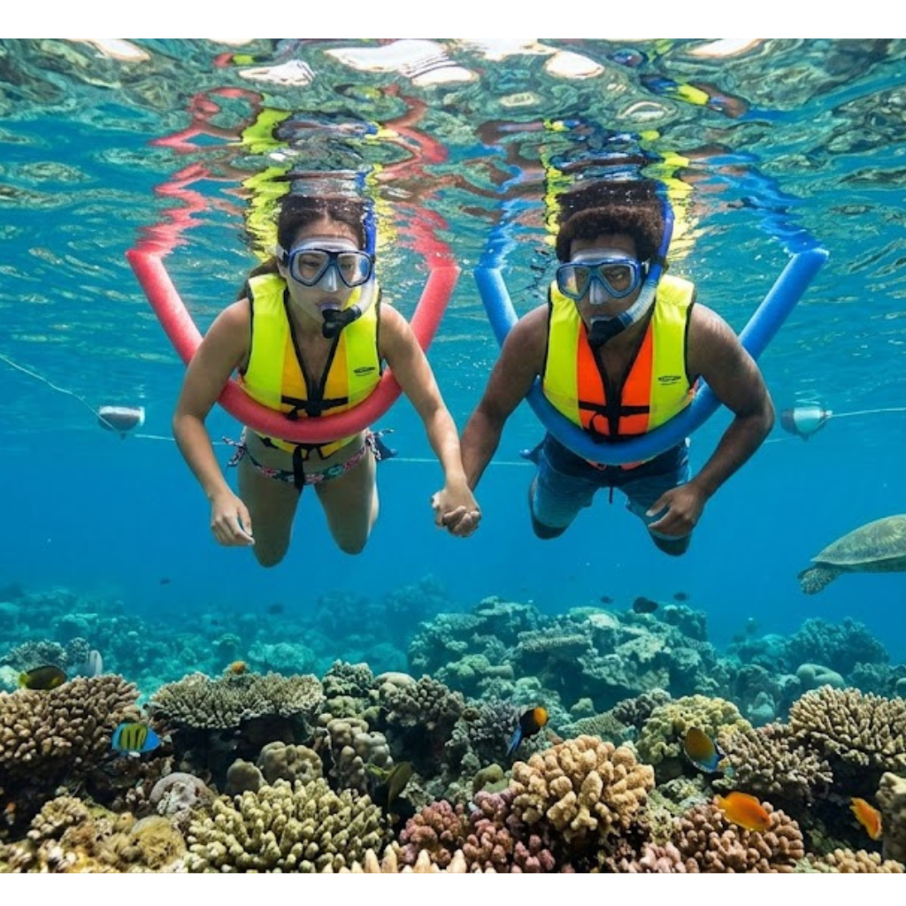 Two snorkelers with life vests exploring vibrant coral reef. Snorkeling in Kona Safe for Beginners