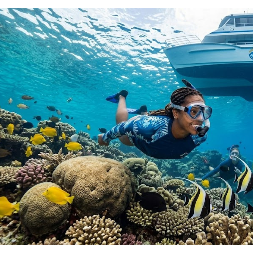 Snorkelers explore vibrant coral reef near a boat.
